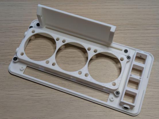 A photo of a 3D printed part of a PC case. It's the front panel with openings for a CD drive, cooling fans, ports and buttons.