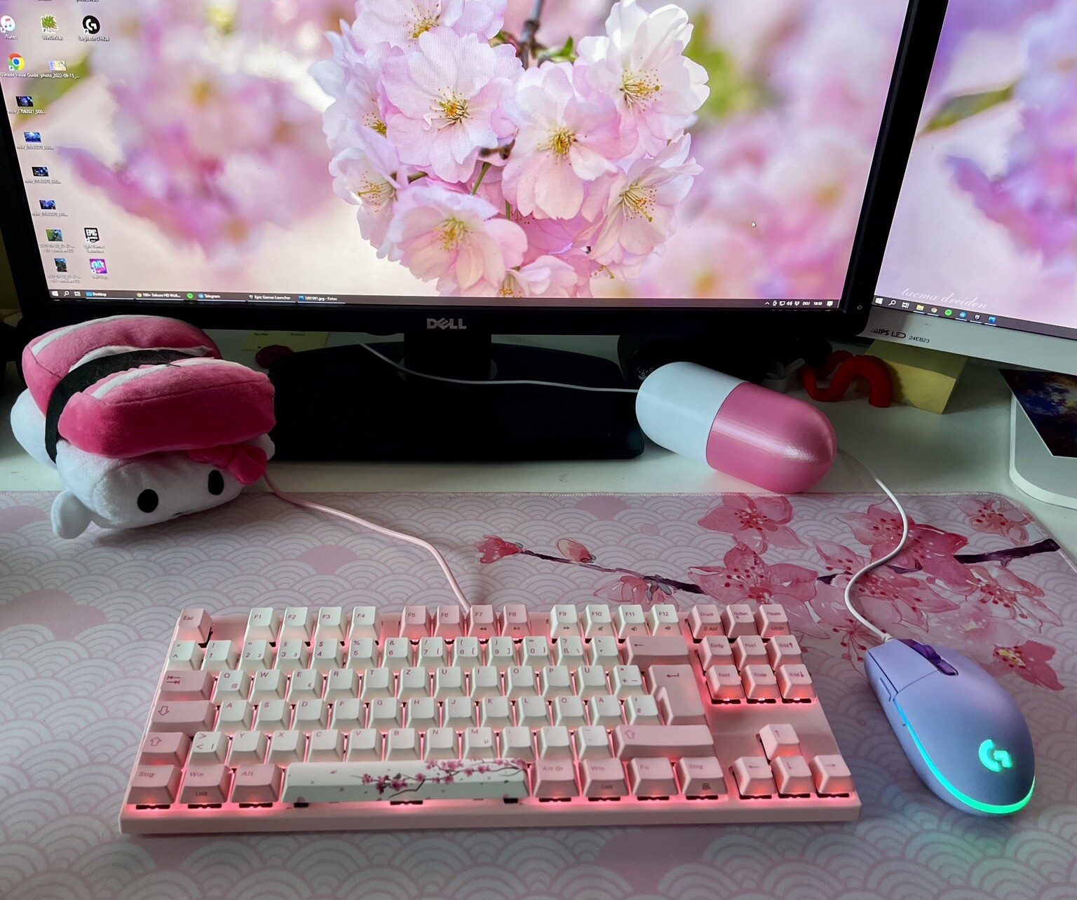 keyboard with Cherry blossom design in front of 2 monitors