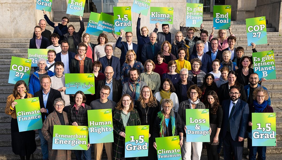 Auf dem Foto steht ein großer Teil der Grünen Bundestagsfraktion auf den Stufen vor dem Reichstagsgebäude. Sie halten Schilder hoch, auf denen u.a. steht: Climate Finance, COP 27, Erneuerbare Energien, Human Rights, 1,5 Grad, Climate Feminism, Loss & <br />Damage, Es gibt keinen Planet B, End Coal, Klimaaußenpolitik, Rettet die Regenwälder.