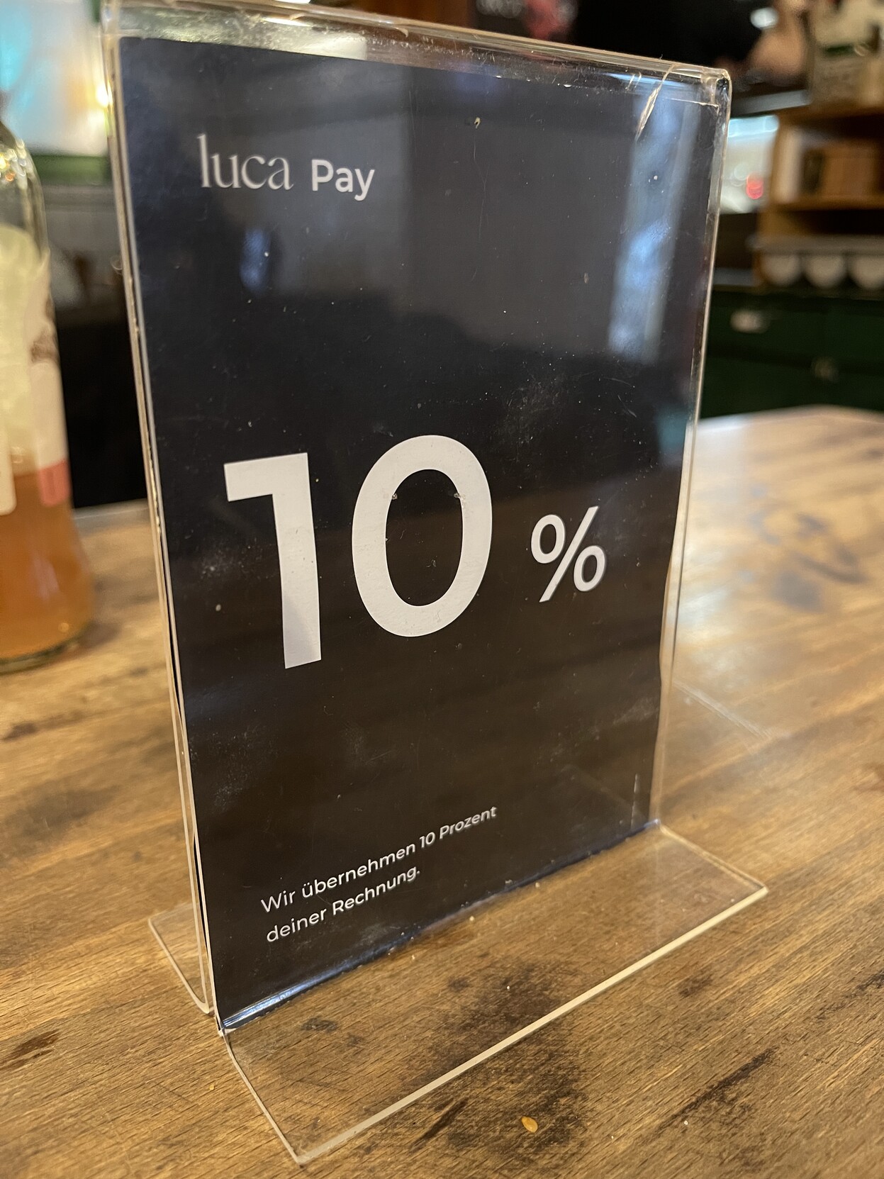Tischaufsteller im Restaurant: „Luca Pay - Wir übernehmen 10% deiner Rechnung“