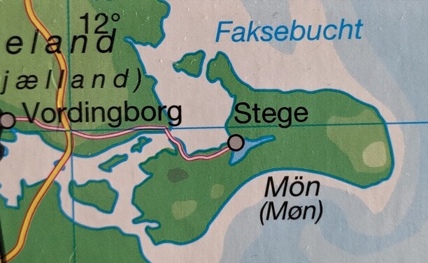Foto. Kleiner Ausschnitt einer gedruckten Karte. Inseln und Festland, Ortsnamen wie "Vordingborg", "Stege", "Møn". Im Meer neben einer Insel in Hellblau der Name "Faksebucht".