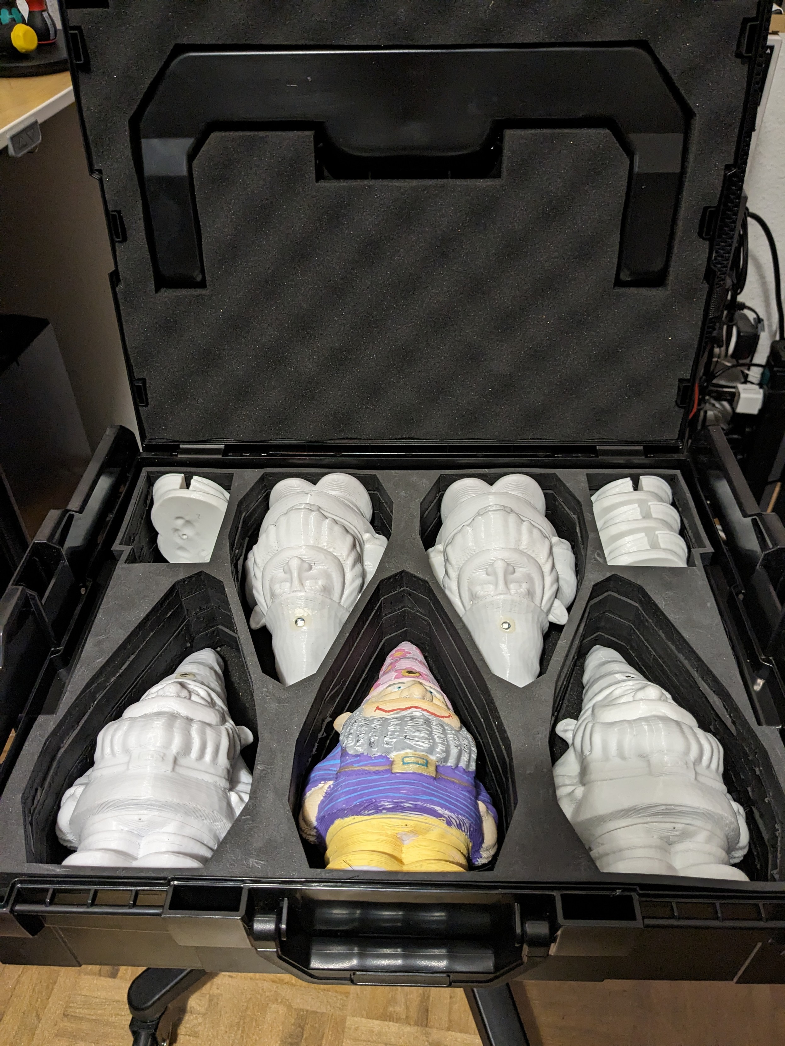 The open box on a chair. Five datagnomes are inside, each in its own compartment in a custom foam insert. There's also two smaller compartments holding extra gnome feet.