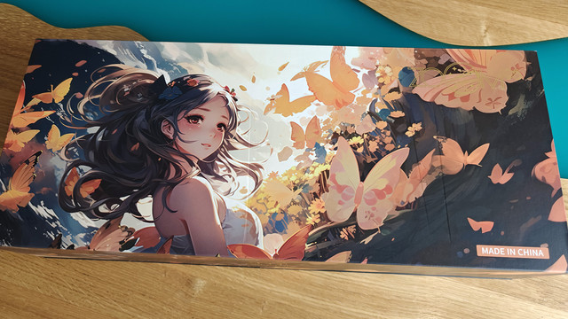 The box of a Zoom98 keyboard. Box art is colorful comic-style and features a woman with black hair blown around by wind in a white dress, surrounded by butterflies. Butterflies of various sizes are everywhere.

Bottom right says "made in China", top right has a barely visible gold Zoom98 logo.