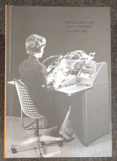 Black and white cover of Shift Happens volume 1, showing a woman sitting in front of a typing device from probably the 50s.