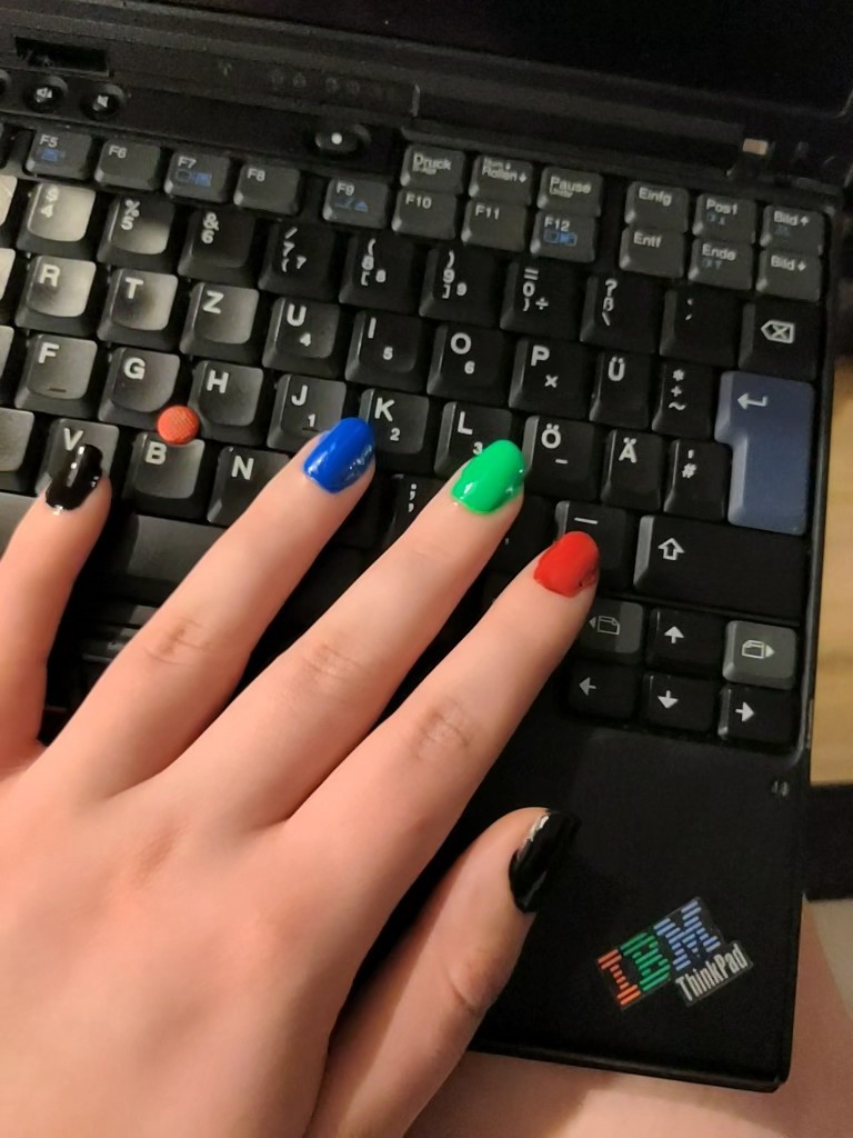 Nails in IBM color on top of an IBM ThinkPad