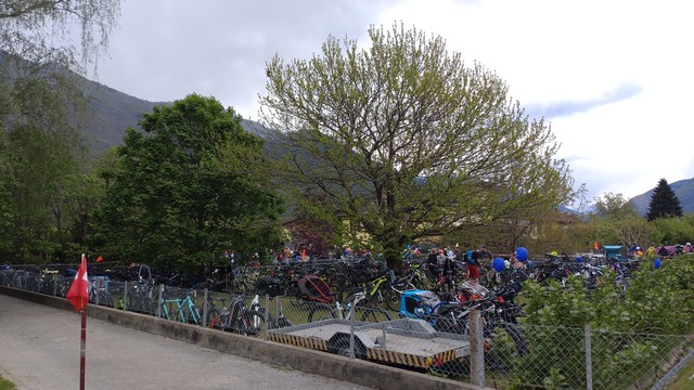 A fenced garden full of parked bicycles.