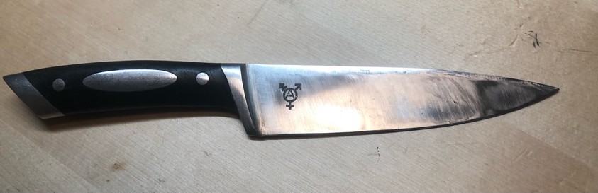 a kitchen knife with a trans anarchy symbol on it 