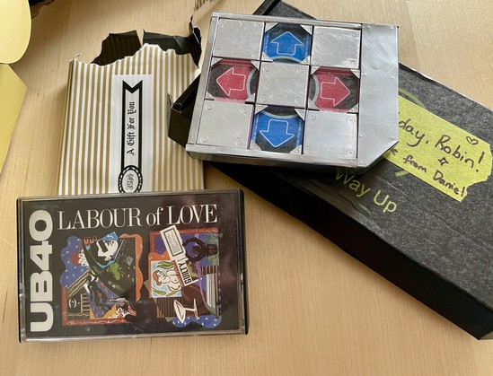 A cassette tape (UB40, geddit), and a tiny DDR  pad (handmade, little metal bits with stamped screws and acrylic arrow buttons), with their respective wrappings and birthday messages. 