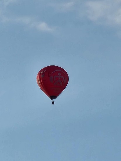 Unbearbeitetes Foto mit dem roten Heißluftballon in der Mitte des Bildes.
