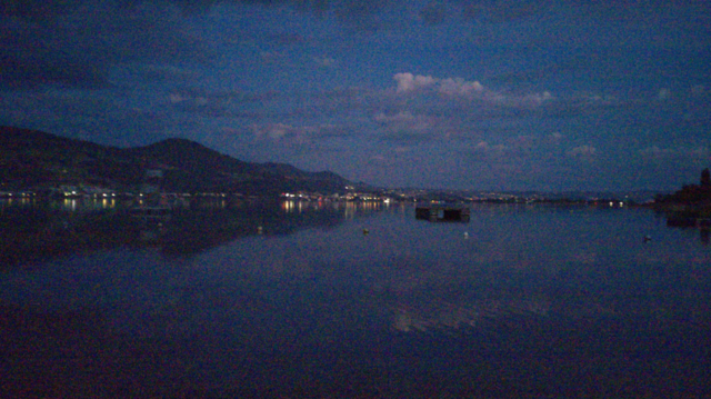 Dawn view from Jona delta towards west onto the Lake Zurich. Already many lights can be seen on the lakeside. The blue (but still a bit dark) sky has some grey-pink clouds.