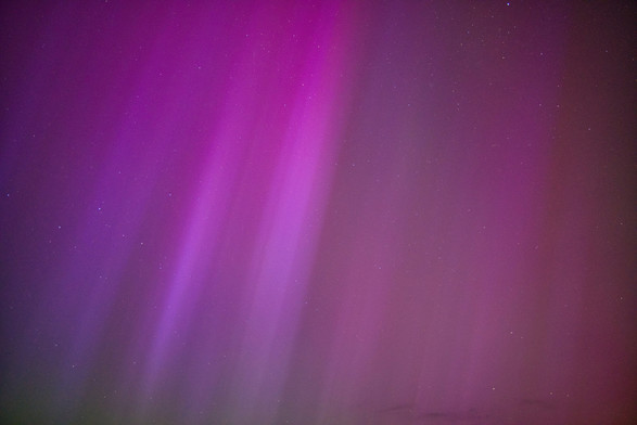 Picture of a night sky, with aurora borealis, pink/purpleish colors visible