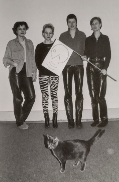 Black and white photo of the band Kleenex with a black cat in front