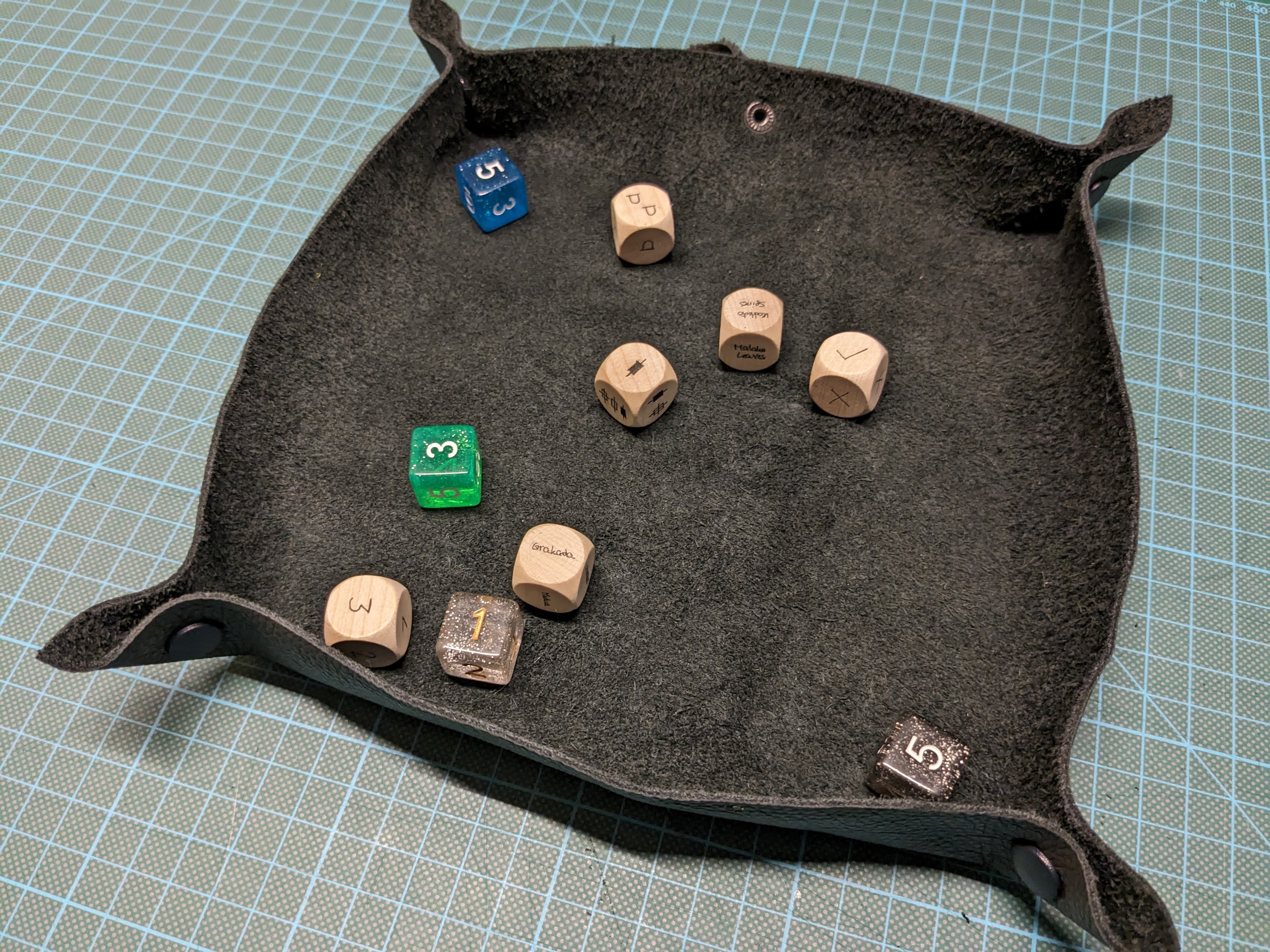 The leather square unrolled and the buttons snapped together. It's now usable as a dice tray.