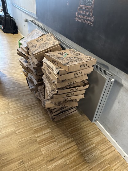 Ein Berg von ca. 40 leeren Pizza Kartons. 