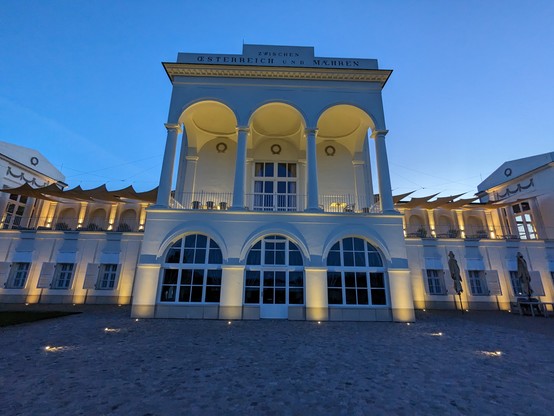Herrschaftliches Gebäude in Hlohovec. Hohe Säulen, viele Fenster, in der Abenddämmerung und beleuchtet, blau gelbe Erscheinung dadurch