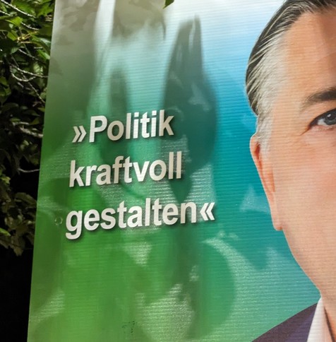 Ausschnitt eines Wahlplakats auf dem, neben eines Ausschnitts des Politikerkopfes, der Slogan "Politik kraftvoll gestalten" zu sehen ist.