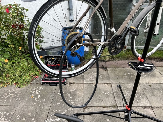 Fahrrad auf einem Reparaturständer mit Werkzeugen auf dem Boden