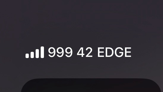 iPhone signal strength with full signal bars, a network name of ‘999 42’, and an EDGE service indicator