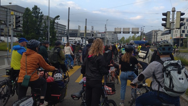 The crowd of bicycle riders waits before the tramway crossing is released by the police.