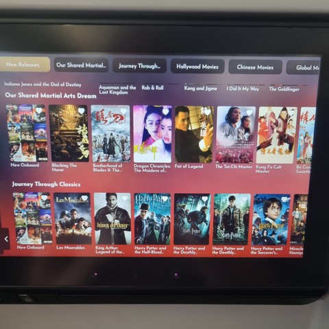 Photo of a plane movie selection, including four harry potter movies visible on screen