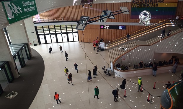 Blick nach unten, man sieht ein grünes Refugees welcome Banner mit Aufschrift Fluchtwege freihalten 