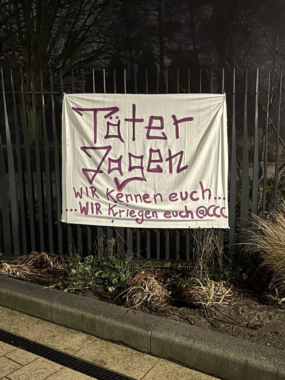 Banner vor dem CCH mit der Aufschrift „Täter Jagen - WIR kennen euch… …WIR kriegen euch @CCC“