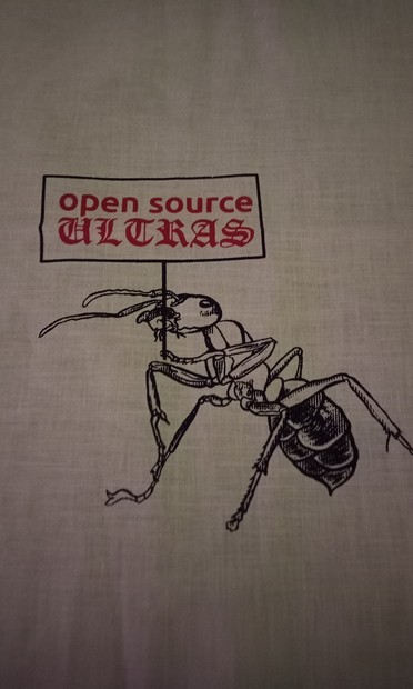 Eine Ameise hält ein Schild auf dem steht Open source Ultras