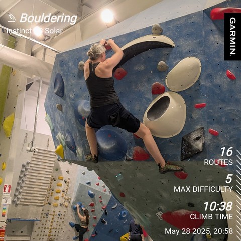 Me topping a boulder. 

Stats overlay shows 16 routes, max difficulty of 5, 10:38 climb time