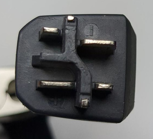 a "power" plug that has a crocked asymmetric middle divider wall made of plastic or rubber, which also branches off to the left. at the top a metal connector to the left of the divider, a metal pin on top of the divider, and a bit lower than the left one also a metal prong to the right of the divider. below the branching off-to-the-left divider there is a similar setup of three metal prongs to the left, bottom and right of the plastic divider.