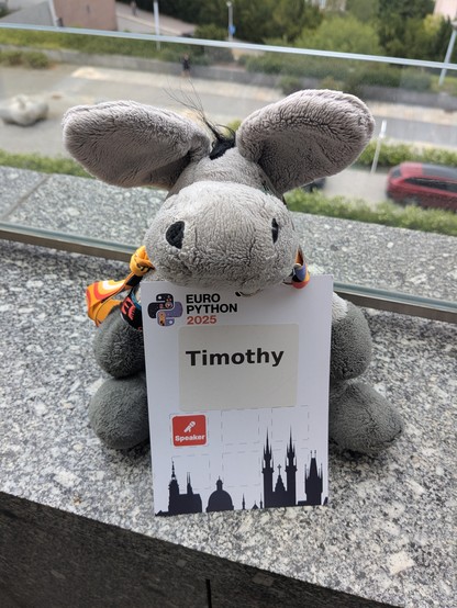 Plush donkey Timothy proudly holding up his own conference badge