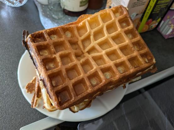 A picture of a rectangular waffle with the typical grid pattern on top. But the grid has a dent at one point and it looks like the often used representation when explaining gravity.